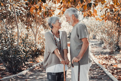 Couple de personnes âgées avec cheveux poivre sel se promenant en forêt
