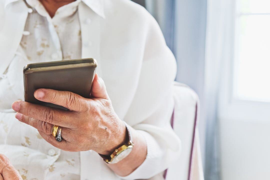 close-up-image-of-senior-woman-using-her-mobile-ph-2024-07-29-18-00-47-utc