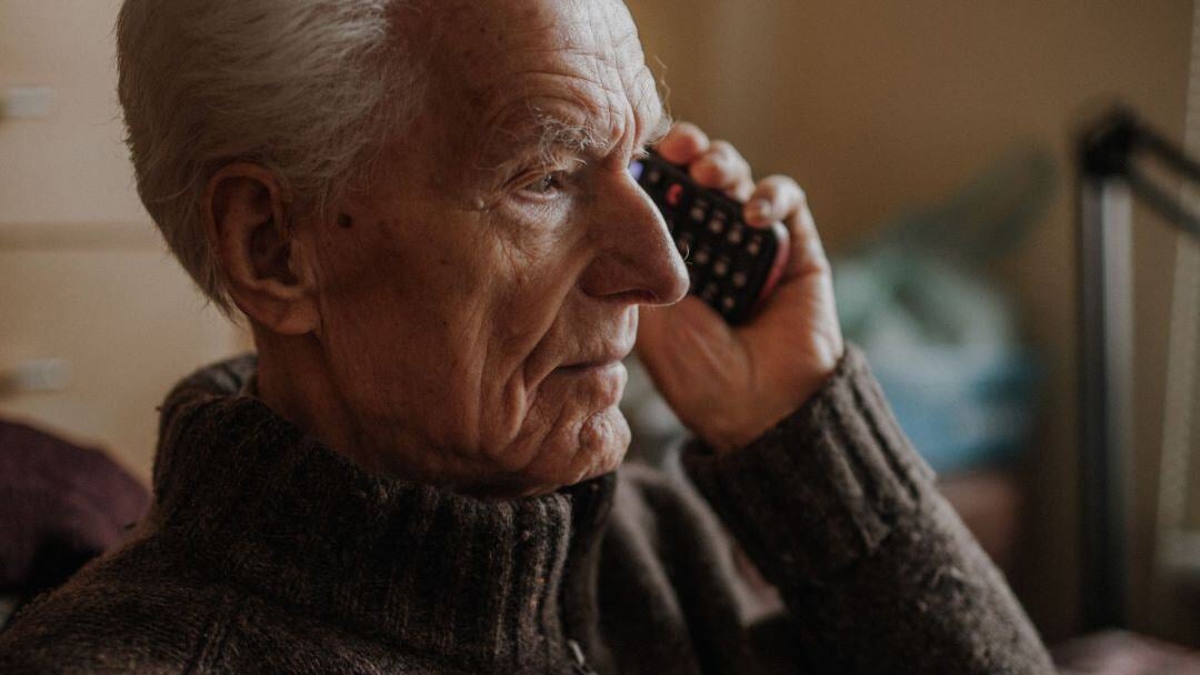un homme retraité à l'air contrarié parle au téléphone